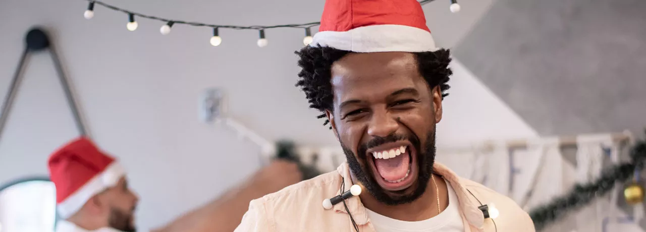 Foto mostra colegas de trabalho animados ao fazer a decoração de natal no escritório