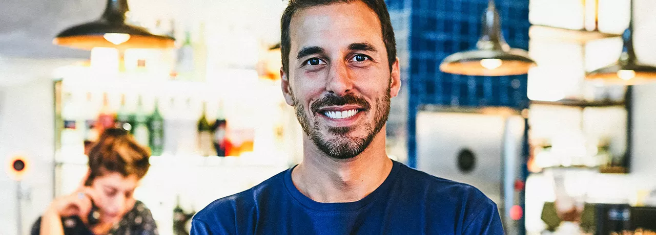 jovem em frente a próprio negócio.