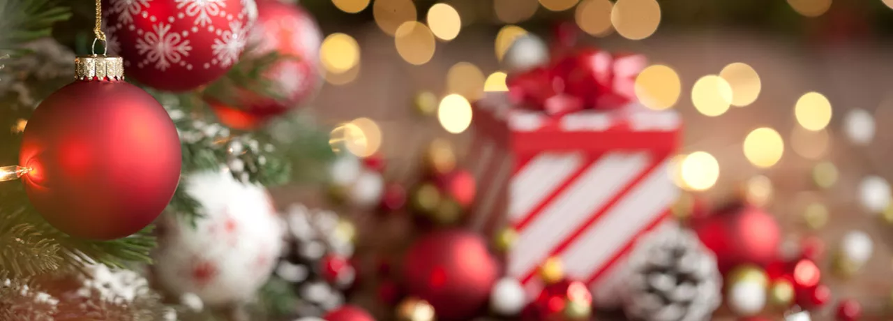 Imagem mostra uma mesa de Natal com um presente ao fundo