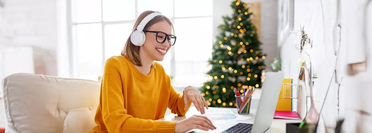 Colaboradora trabalha em home office com árvore de Natal ao fundo