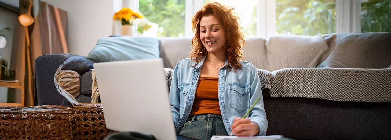 mulher sorrindo em frente ao computador.