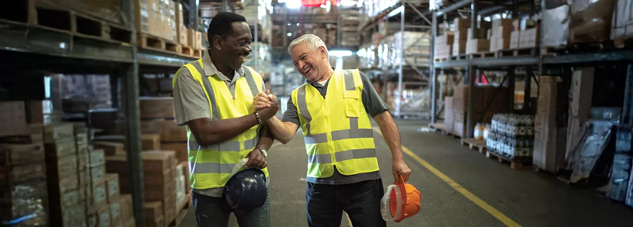 Foto mostra dois funcionários de uma empresa comemorando os resultados do final de ano