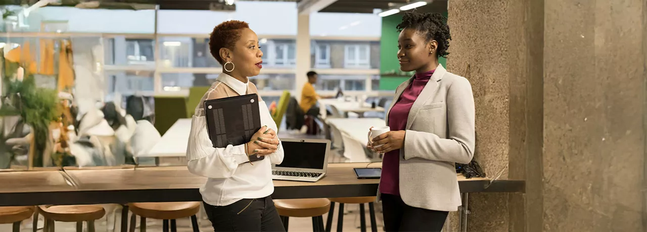 Duas pessoas conversam no escritório