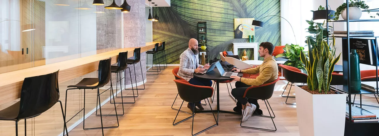 Imagem mostra duas pessoas em reunião no escritório