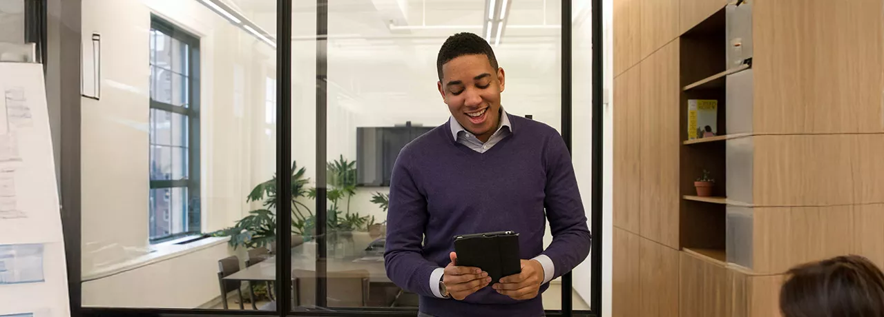 Foto mostra uma pessoa no escritório trabalhando no seu tablet