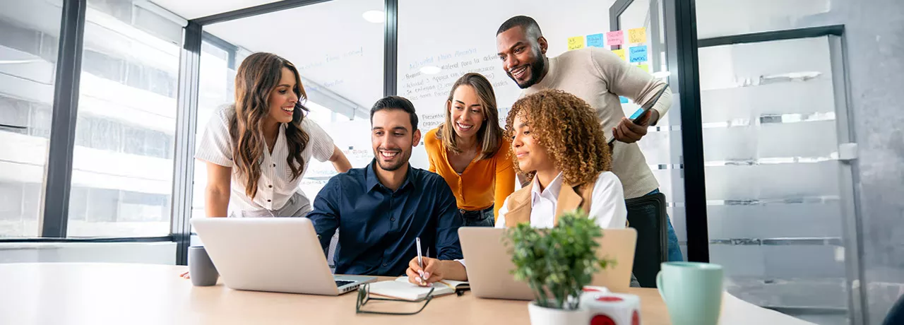 time reunido em torno de notebook.