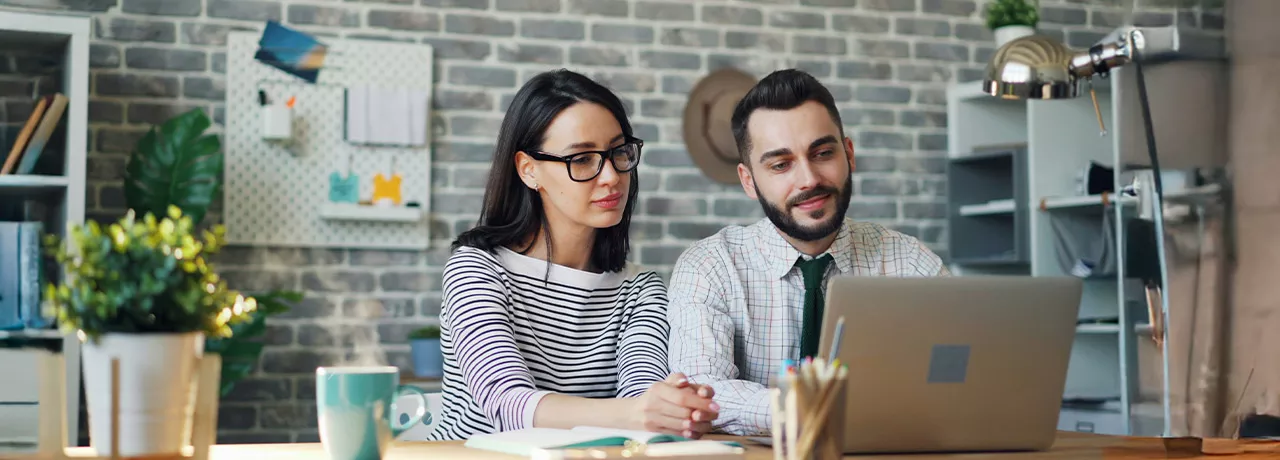 Foto mostra um chefe trabalhando uma pessoa de sua equipe