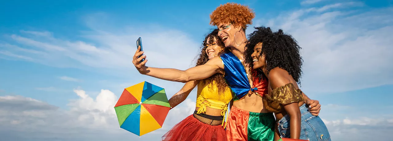 pessoas com roupa de carnaval tirando foto.