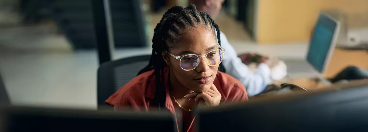 mulher olhando para computador pensativa.