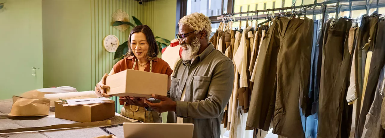Microempresária trabalha com seu funcionário na loja de roupas