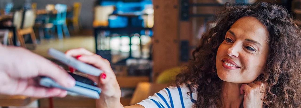 mulher pagando compra com celular.