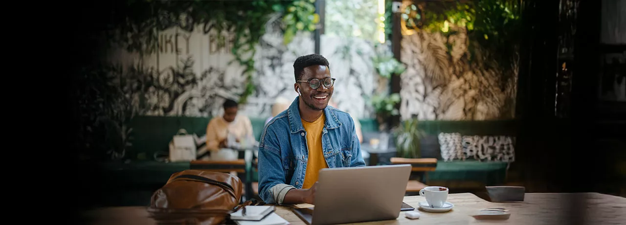 homem sorrindo enquanto usa o notebook.