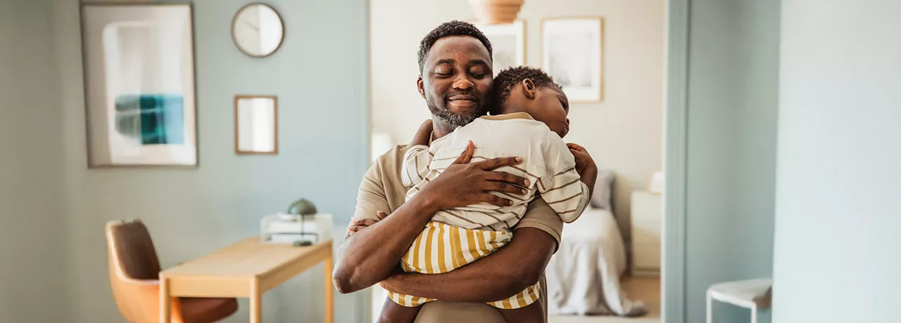pai segurando o filho no colo.
