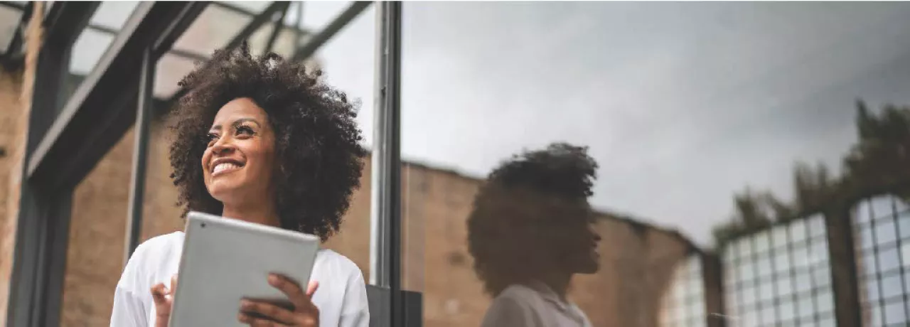 Mulher negra com tablet sorrindo