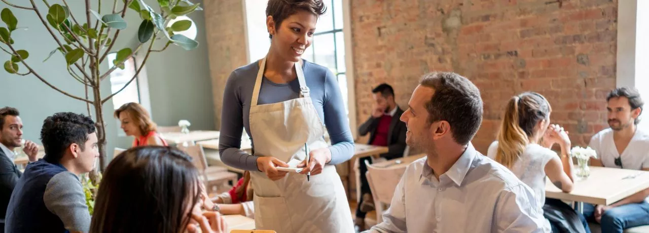 homem em restaurante sendo atendido por uma mulher