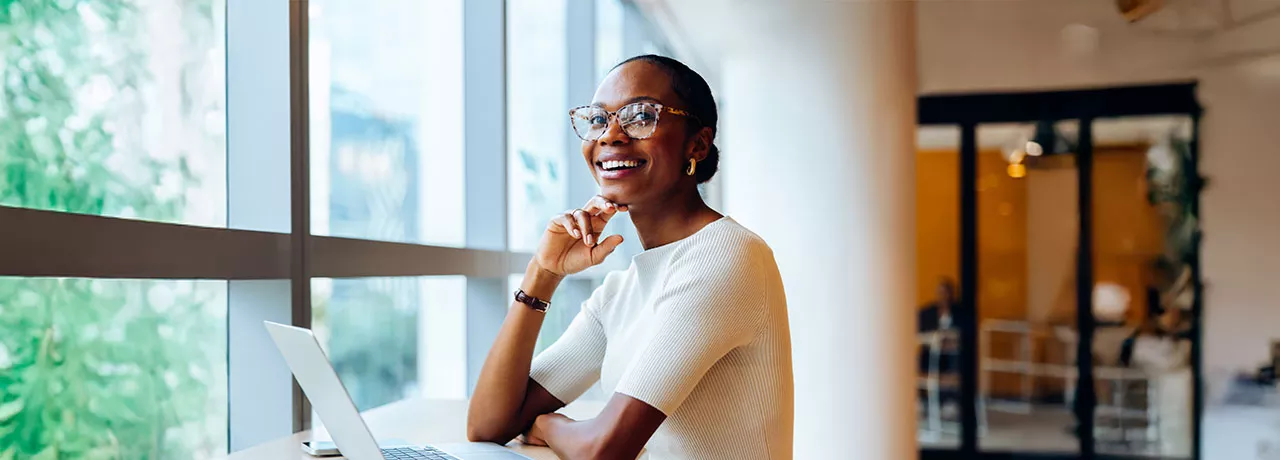 Foto mostra uma mulher animada no seu local de trabalho