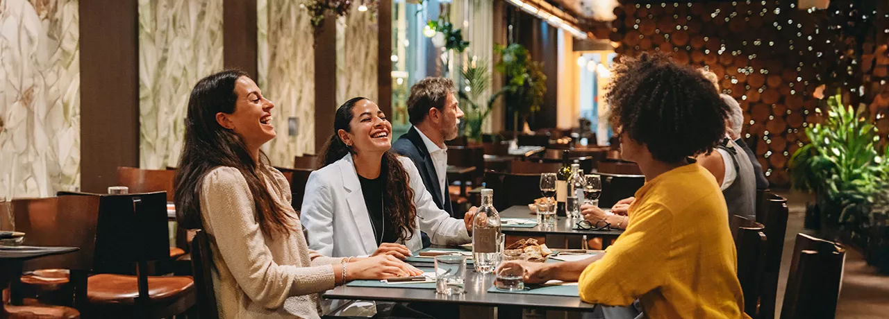 Imagem mostra 3 amigas almoçando juntas na pausa do trabalho