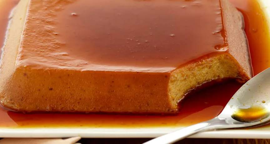 uma travessa braca com servindo um pudim de banana com cobertura caramelizada 