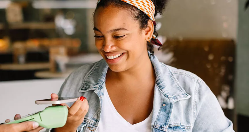 Mulher paga conta em café usando seu cartão Pluxee no Apple Pay