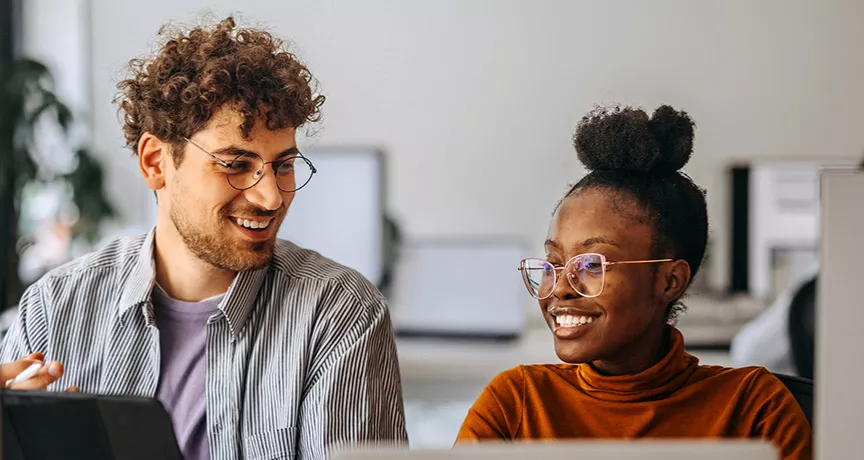 Dupla de colegas de trabalho trabalha tranquila no ambiente saudável de uma empresa humanizada