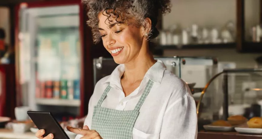 Empreendedora confere o fluxo de vendas em seu estabelecimento. Veja no infográfico como começar a empreender.
