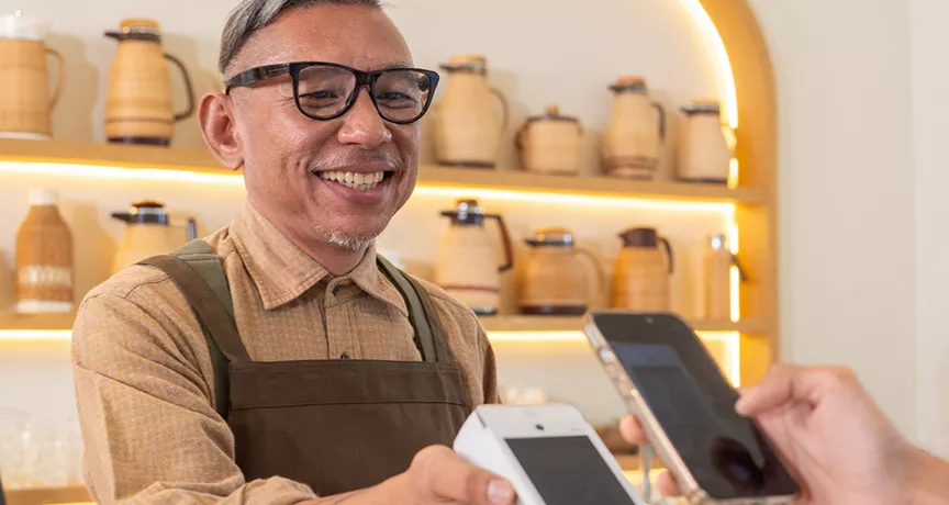 Dono de estabelecimento aceita pagamento com Pluxee Gift pelo smartphone do cliente