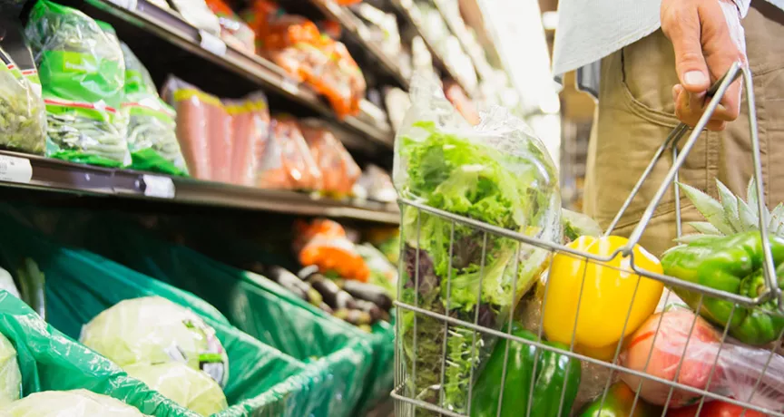 Pessoa escolhe verduras e legumes frescos em um supermercado