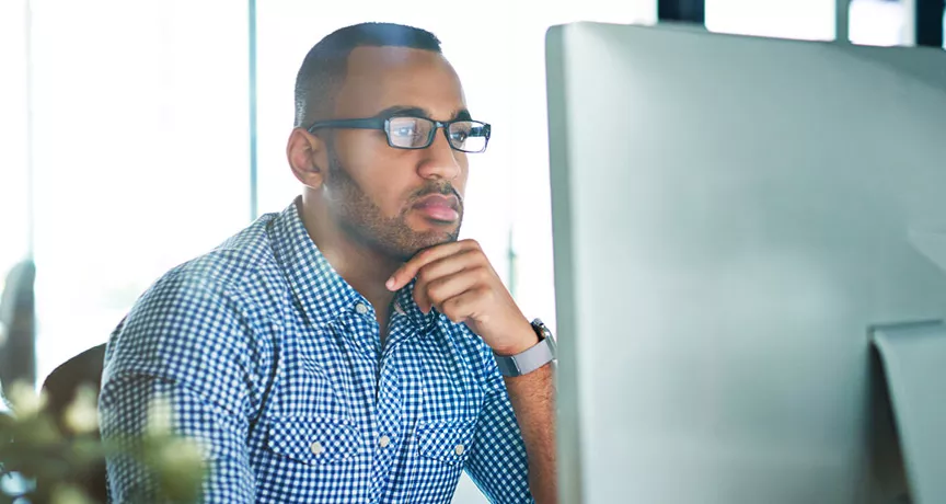 Foto mostra empresário concentrado na tela do computador