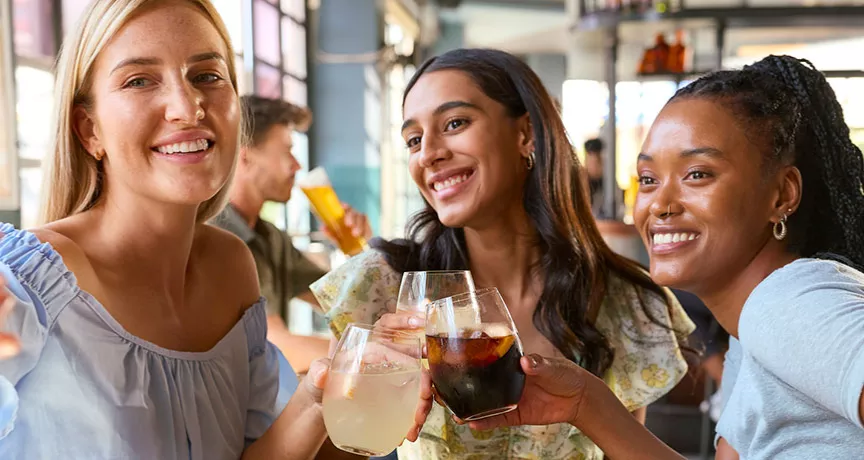 Foto mostra 3 amigas tirando uma foto juntas no restaurante