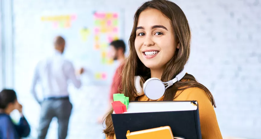 Jovem profissional está no escritório levando material para sua reunião