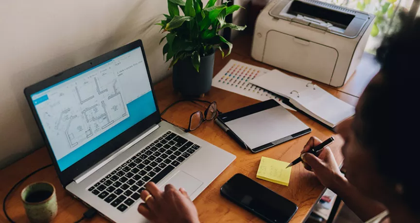 Mulher trabalha no escritório que montou em sua casa