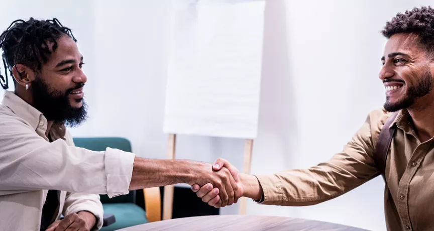 O novo funcionário cumprimenta com um aperto de mão um de seus novos colegas de trabalho