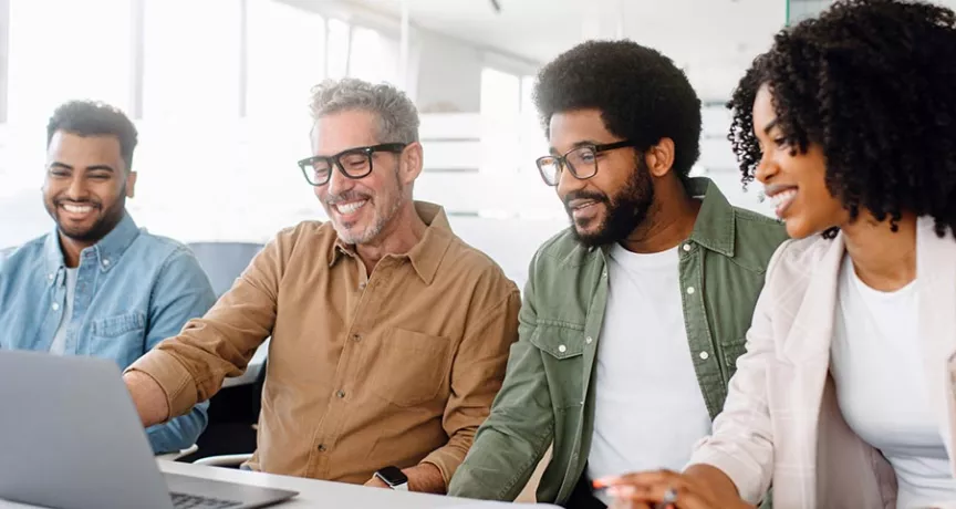 Equipe de quatro pessoa trabalha junta em um escritório