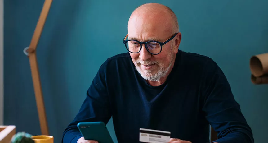 Foto de um homem usando o celular em sua casa