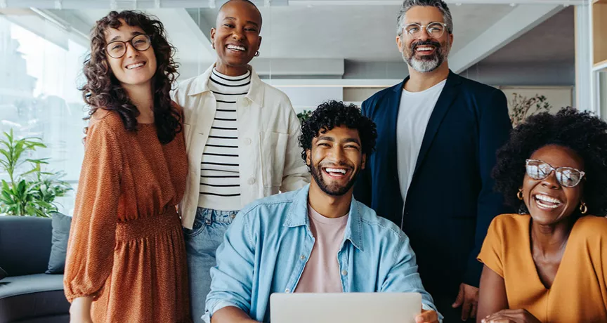 Imagem mostra uma equipe de trabalho motivada e feliz no escritório
