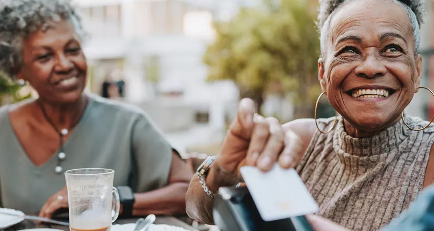 Duas mulheres utilizam pagamento por aproximação para pagar a conta do restaurante