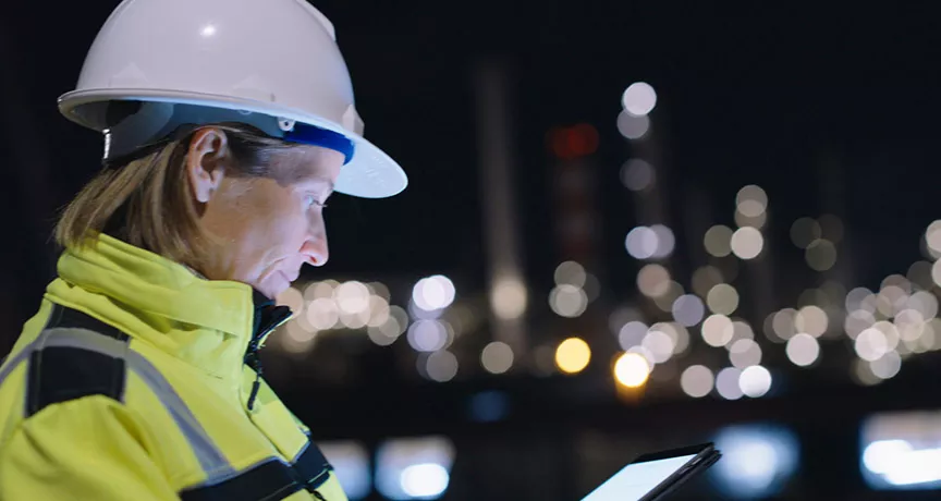 profissional com capacete de proteção trabalhando à noite.