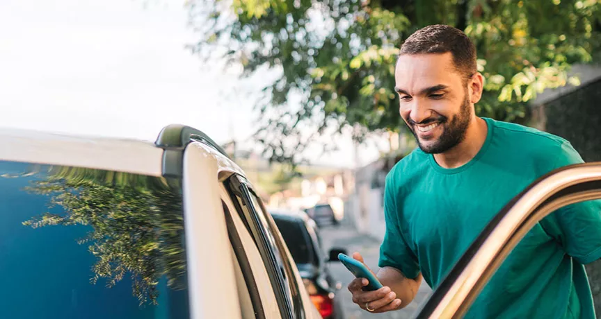 homem sorridentes entrando em seu carro.