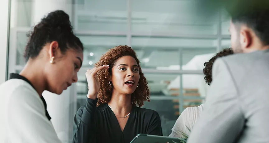 pessoas em uma reunião discutindo sobre uma matriz de competências.