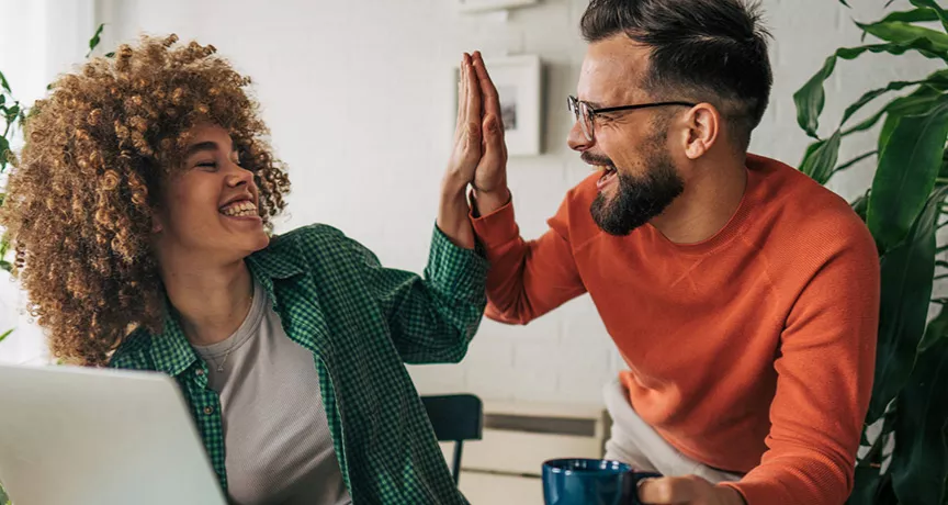 Dois colegas de trabalho comemoram o prêmio recebido pela Pluxee Brasil