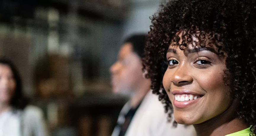 Profissional sorri na fábrica em que trabalha