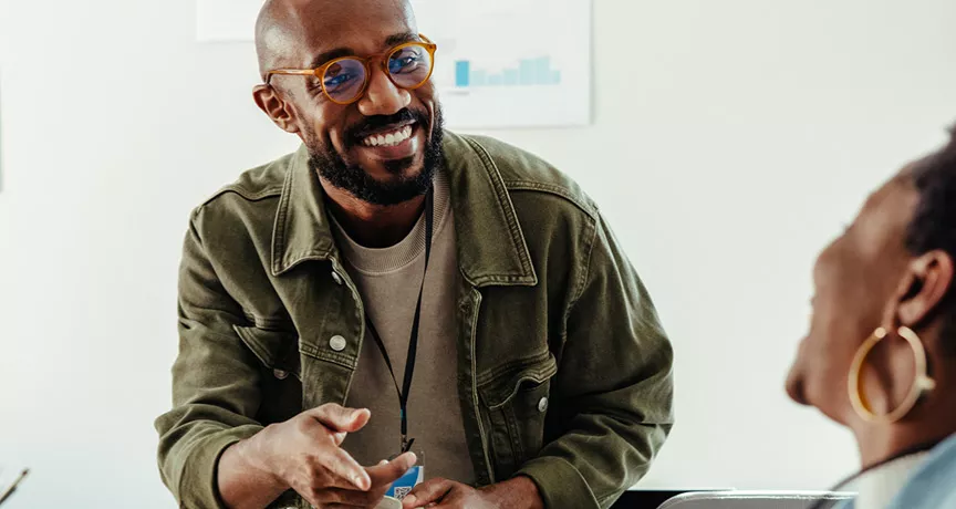 Dois colegas de trabalho conversam amigavelmente depois de uma reunião