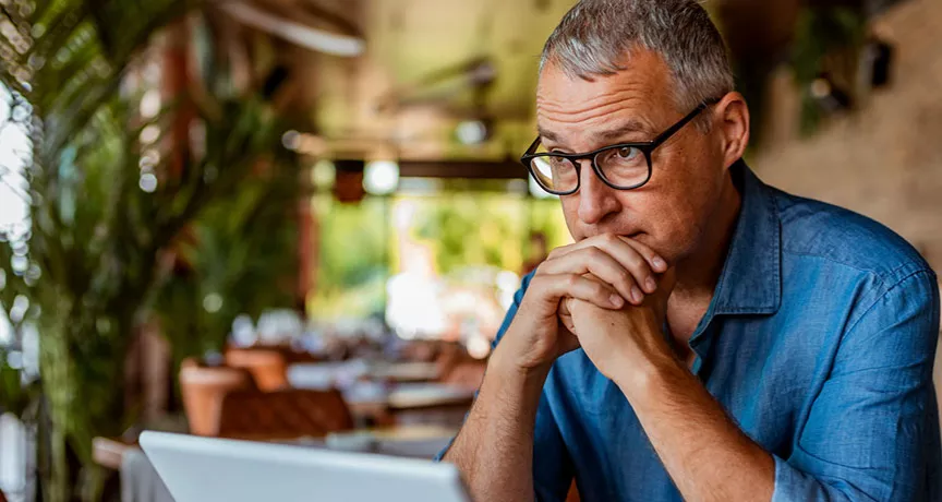 homem olhando para computador preocupado.