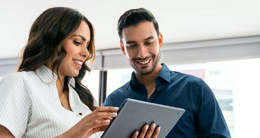 uma mulher e um homem olhando para algo em um tablet.