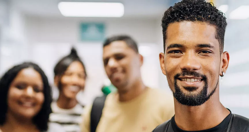 vários jovens sorrindo em ambiente corporativo.
