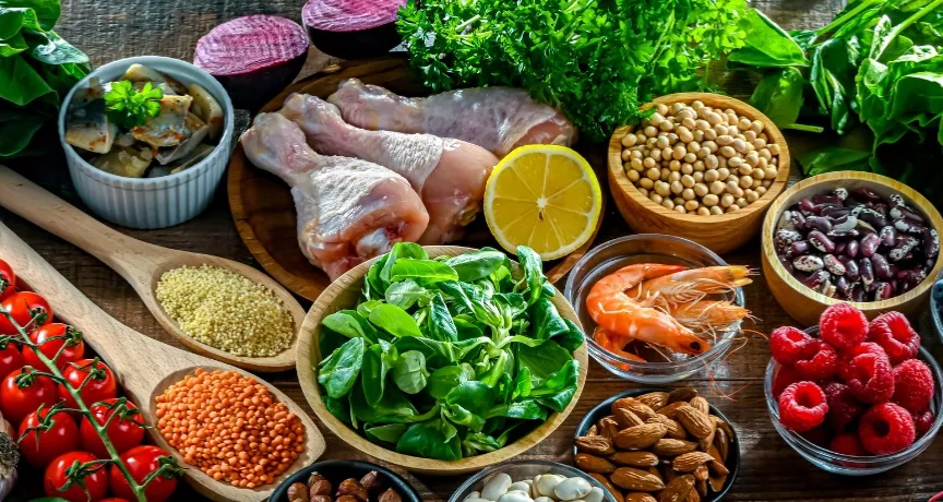 A imagem mostra temperos, frutas, proteínas e saladas todas juntas