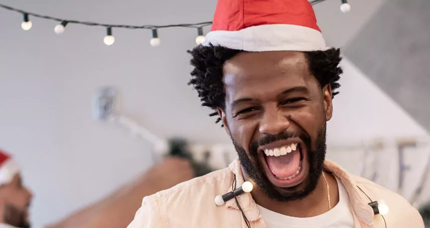 Foto mostra colegas de trabalho animados ao fazer a decoração de natal no escritório