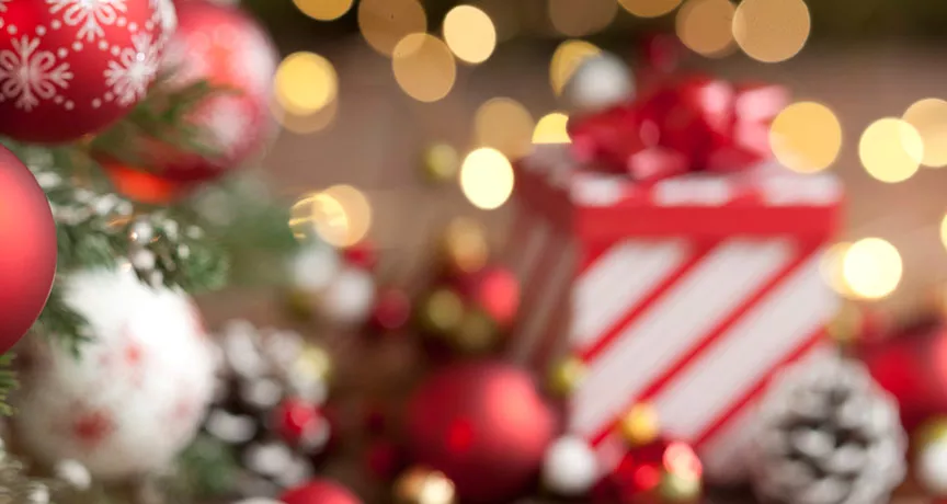 Imagem mostra uma mesa de Natal com um presente ao fundo