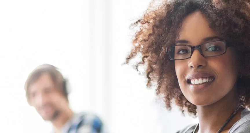 mulher sorrindo para a câmera em ambiente de trabalho.
