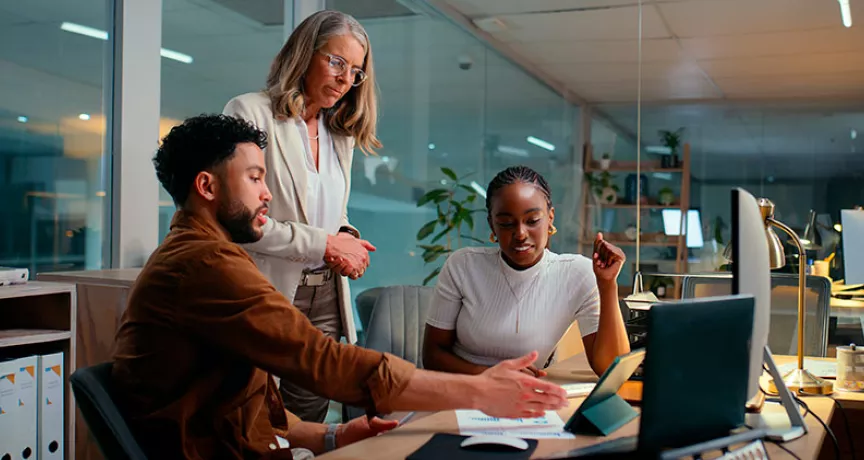 Foto mostra uma equipe fazendo reunião de trabalho numa sala